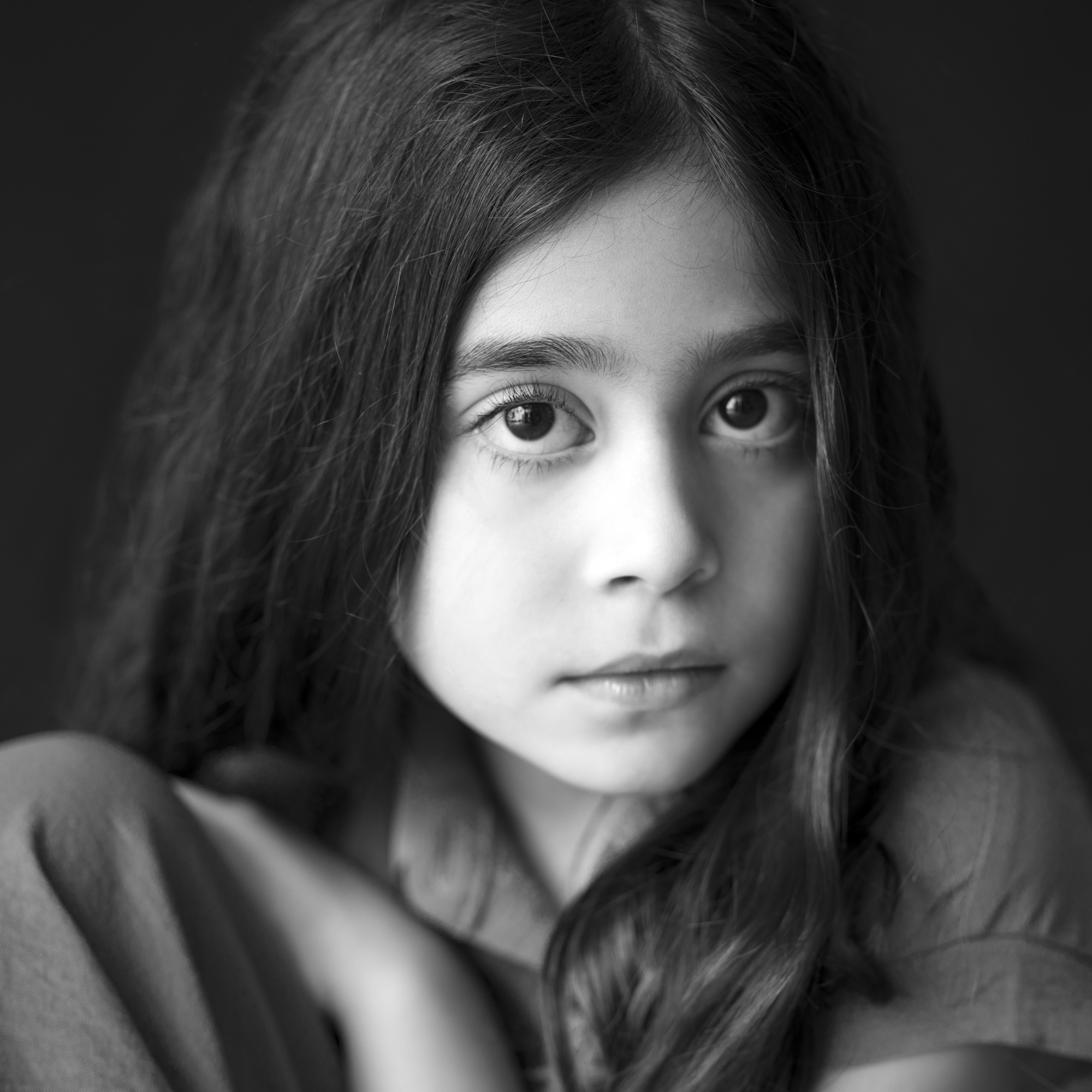 Black-and-white close-up portrait of a young girl with long, straight hair, gazing softly at the camera, by Jerome Art Photography.